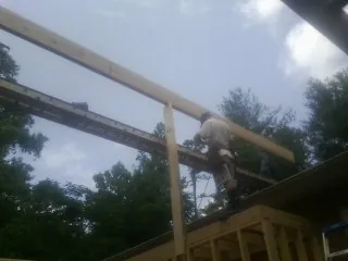 Carpenter setting a ridge beam over a new addition frame — Ice Dam Removal by Roofing Brothers in Bridgeville